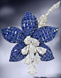 Van Cleef and Arpels / A sapphire and diamond 'Fuschia' brooch, by Van Cleef & Arpels, 1987. The mystery-set calibré-cut sapphire petals, issuing an articulated cascade of pear-shaped diamond stamen, to a pavé-set brilliant-cut diamond trumpet and gra