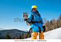 Male skier taking a selfie using his action camera and a selfie stick technology recreation activity in winter ski resort