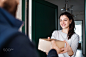 Woman receiving parcel from delivery man at the door. by Jozef Polc on 500px