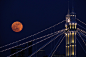 #花瓣爱旅行#橘色圆月：2012年2月7日，英国伦敦艾伯特桥（Albert Bridge ）上空，一架飞机从一轮满月前驶过。艾伯特桥堪称伦敦最为浪漫的大桥之一，为英国女王伊丽莎白二世登基60周年“钻石庆典”举行庆祝的舰队将以这里为起点，沿着泰晤士河航行。 

（图片来源：Dan Kitwood/盖蒂图片社）