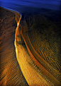 [沙蛇（Sandsnake）] 国家摄影师Christer Johansson在瑞典拍摄的作品《沙蛇（Sandsnake）》，拍摄于日出时分瑞典维纳恩湖的沙滩，波浪造就的沙子形态令人着迷。非常棒的抽象照片，独一无二，色彩、质地和光线都很完美，形状、色调和图案都绝无仅有。铜色和金色相交，金属质感跃然纸上，纹理和细节同样惊人。