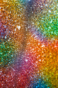 闪烁的彩虹背景与模糊。微距图像的金属光泽表面的不同颜色斑点。垂直的抽象
