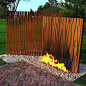 Laser cut corten steel behind fire