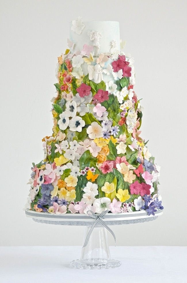 精致的鲜花堆砌的婚礼蛋糕，喜爱花朵的新娘...