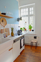 white kitchen cabinets with white tile backsplash and blue-painted wall
