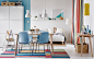 色彩缤纷的开放式餐厅和客厅内放着轻盈的木质桌子和蓝色椅子。