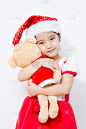 亚洲小女孩在圣诞节拥抱熊娃娃