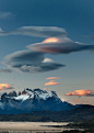 智利上空出现“UFO云”【荚状云是一种自然天气现象】近日，一名俄罗斯业余摄影师在智利的百内国家公园拍到了一幅奇景。天空中出现了几朵碟形云彩。它们在阳光的映照下呈橘黄色，像极了科幻电影中的UFO。这种“UFO云”的学名叫荚状云，是一种自然天气现象，经常在湿润空气经过山脉上空时出现。如果空气在经过山脉上空时温度下降，空气中的水分就会凝结成荚状云。为了拍摄这些荚状云，47岁摄影师德米特里和他的朋友在冷风里站了好几个小时。不过他表示，能拍到这样的奇景，他觉得这一切都是值得的。