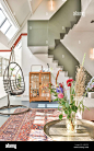 Interior of living room in residential house with carpet on floor cupboard near swing egg chair and staircase Stock Photo - Alamy : Download this stock image: Interior of living room in residential house with carpet on floor cupboard near swing egg chair 