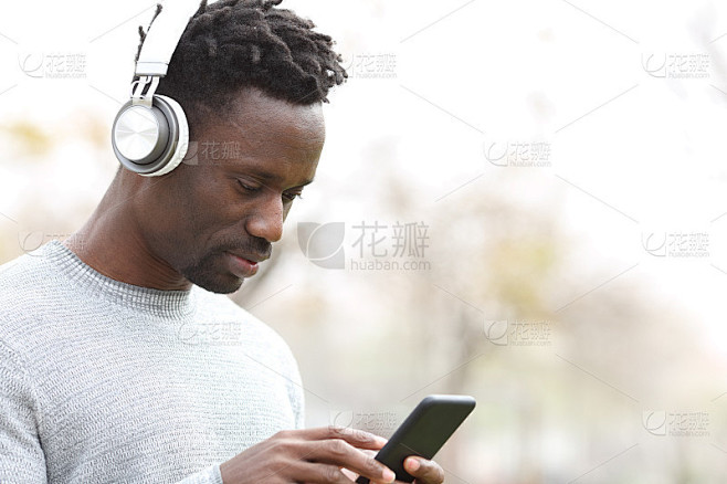 一个用耳机听音乐的黑人