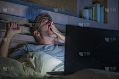 有吸引力的疲倦和压力的工作狂工作到深夜在床上忙着笔记本电脑打哈欠感觉困倦和在商业项目的期限压力概念过