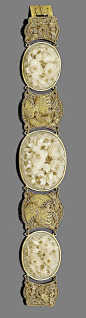 Victorian jewellery: A late 19th century gold and ivory bracelet  Set with three oval ivory plaques, each finely carved in high relief depicting floral bouquets, with graduated gold filigree spacers depicting phoenixes and serpents, Chinese maker's mark, 