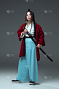 穿着和服的武士拿着武士刀，看着灰色的相机