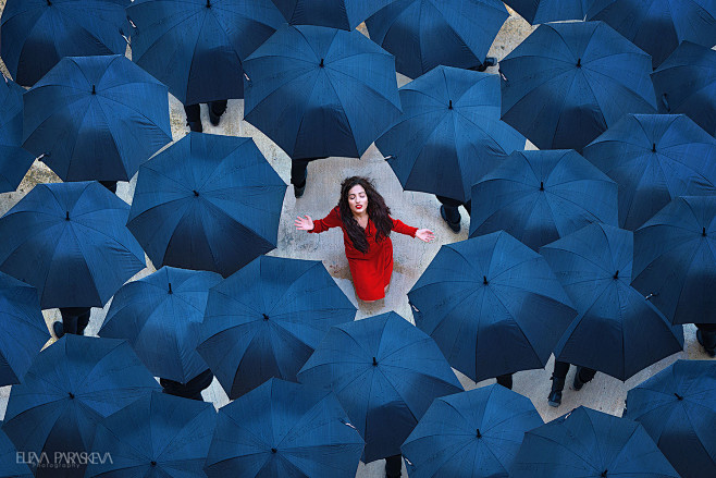 人群，蓝色雨伞，没伞的红衣女人，张开双手...