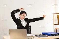 在办公室工作了很长时间后，女商人伸展她的身体。秘书累了又累。女工从忙碌的工作中下班后休息伸懒腰。企业