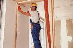 男工人在墙上挂墙纸