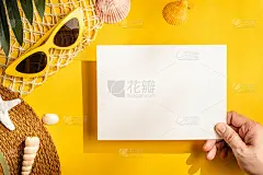 手握纸卡在黄色的夏季硬光与海滩配件。模拟展示设计在夏季概念