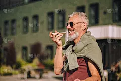 快乐的男性用智能手机录制音频回复