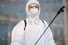 消毒预防COVID-19，人穿防护服喷洒化学品，防止冠状病毒传播，疫情在隔离城市。