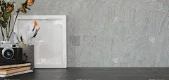 在黑色的桌子和灰色的墙壁上用拷贝空间、相机和办公用品拍摄现代工作场所