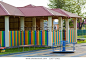 Close-up of bright new alcove with red tile roof and multicolored low fence on green lawn playground in kindergarten. Perfect place for games, recreation and entertainment, built with love and care.