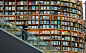 woman standing on escalator near brown wooden book shelves