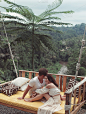 一对夫妇坐在巴厘岛的一个大秋千上