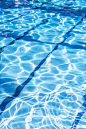 在有阳光反射的游泳池里的波纹水。夏天在游泳池。背景和纹理概念。垂直.