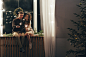 Happy couple playing with sparklers while sitting on window sill during Christmas by fStop_images on 500px