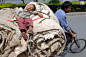 2007年5月7日，湖北襄樊，一名儿童被捆在父亲驾驶的三轮车上睡觉。