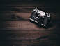 Black and silver camera on brown wooden table