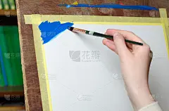 孩子的手拿着画笔，在画布上作画