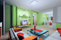 [简约风格淡绿色客厅背景墙装修效果图2013图片]清新的淡绿色风格北京墙面，简约的木质橙色沙发和玻璃茶几，墙角设置的小餐厅，