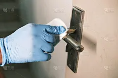 手拿手套用酒精清洁门把手