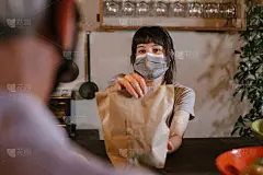 冠状病毒大流行期间，戴口罩的女服务员给顾客点外卖。
