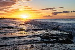 Scenic sunset over the sea. The sun sets on the water.Scenic sunset over the sea. The sun sets on the water. Clouded sky is painted with bright colors. Sunset beach in a summer evening. Brazil.