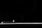 grayscale photogaphy of man sitting on concrete bench