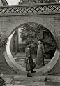 1932年，两个年轻的中国姑娘在庭院月亮门聊天。