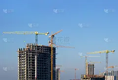 蓝天下，塔吊正在建筑工地上建造一座新的住宅楼。建筑行业的改造方案、发展、理念。