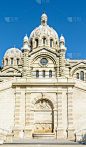 通向马赛的圣玛丽大教堂的双程石阶上凿成的喷泉，蓝色的天空衬托着宗教建筑的圆顶、小礼拜堂和塔楼。