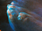 Hubble image of elongated rusty and blue nebula "fingers" whose tips are bright-blue and white