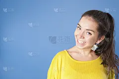 穿着亮黄色毛衣的年轻漂亮的女孩。