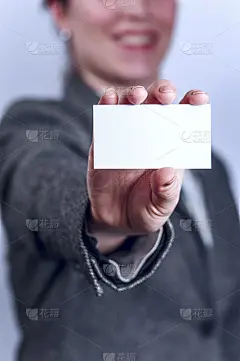 身着灰色西装的年轻女子拿着名片