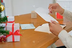 男人打开寄信的圣诞贺卡，送上节日祝福与圣诞装饰
