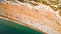 Drone aerial view of a crowded sand beach coastline at Durdle Door