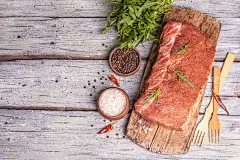 一块生猪肉里脊腌制的新鲜肉与烹饪香料麻绳绑在一起