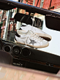 white-super-star-sneakers-with-silver-glittered-star-laced-up-on-rear-view-mirror-of-open-convertible-car
