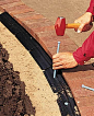 To install a brick border, lay bricks on a compacted bed of gravel and sand. Lock them in place with plastic edging.: 