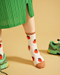 model wearing white socks with tomato print and terracotta accents 