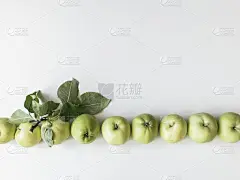 在白色背景上的青苹果和树叶的组成。壁纸的水果。俯视图，平放。